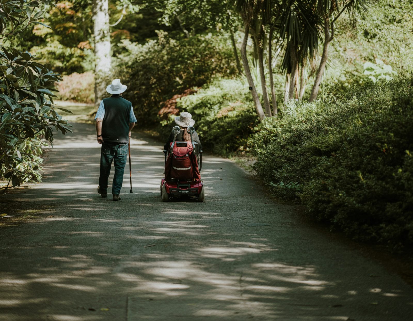 Elderly couple walking along a garden path