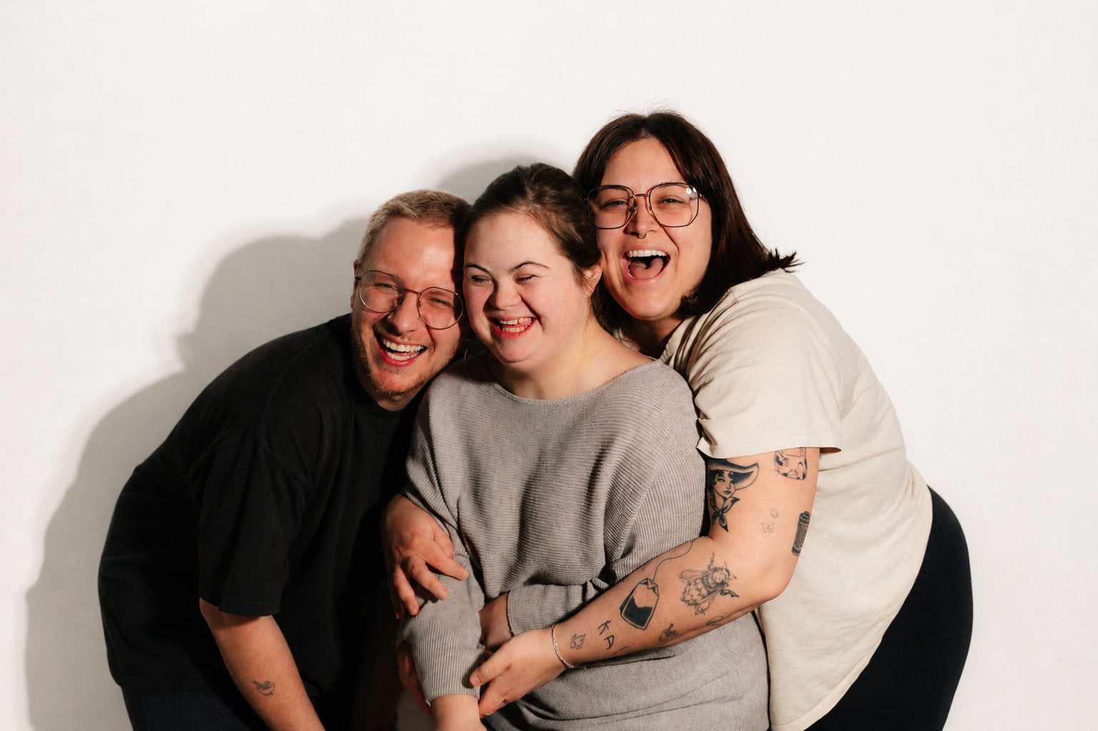 Three friends laughing and hugging together