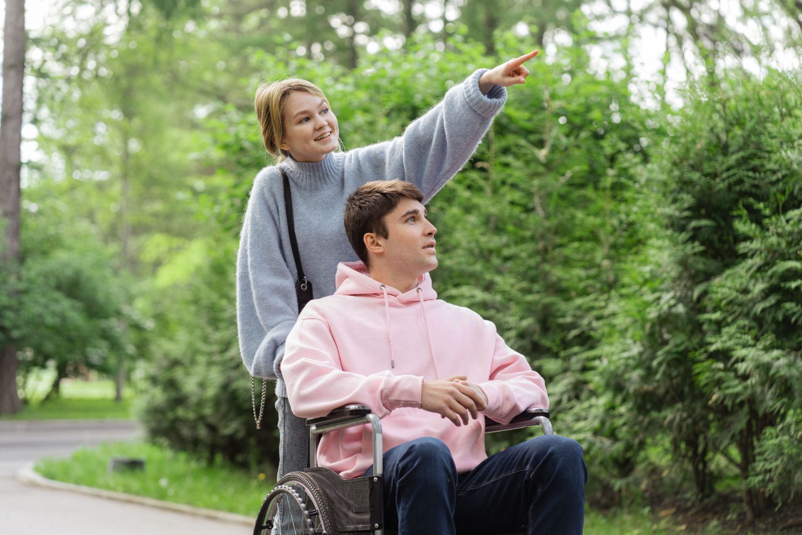 Support worker and a young man in a wheelchair in a park