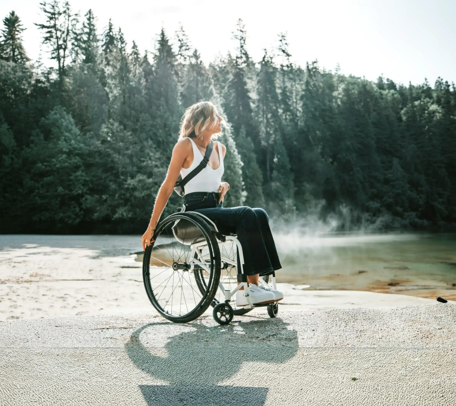 Woman in a wheelchair by a misty lake